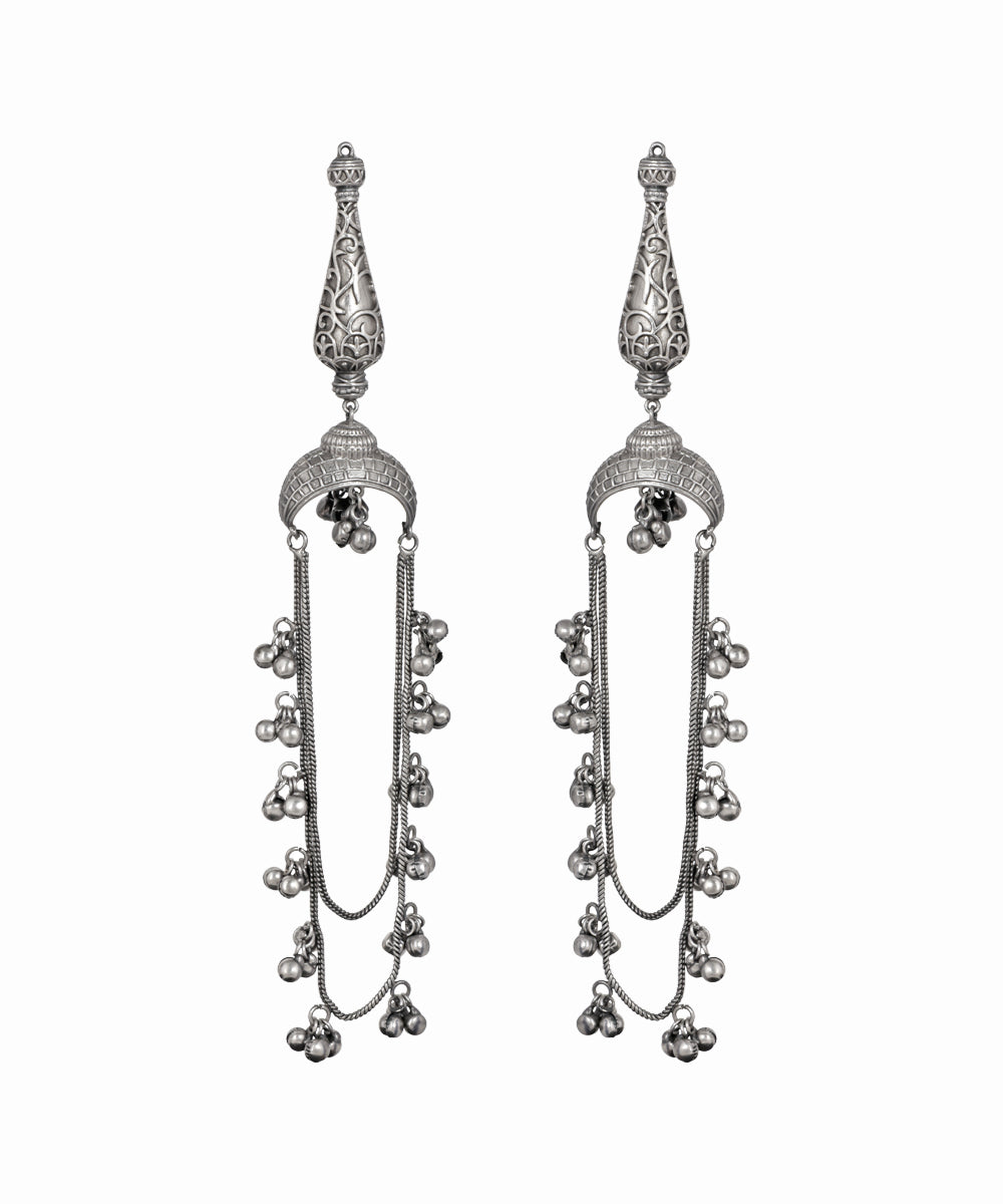 Pair of silver earrings with intricate designs on a white background