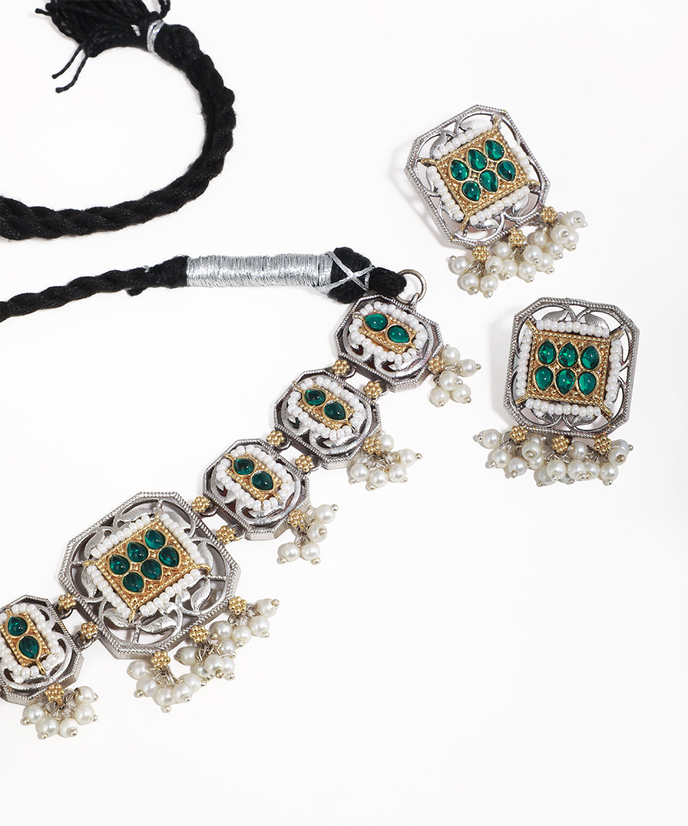 Jewelry set with necklace and earrings featuring green gemstones and pearl accents on a white background.