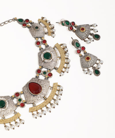 Ornate necklace and earrings with gemstones on a white background