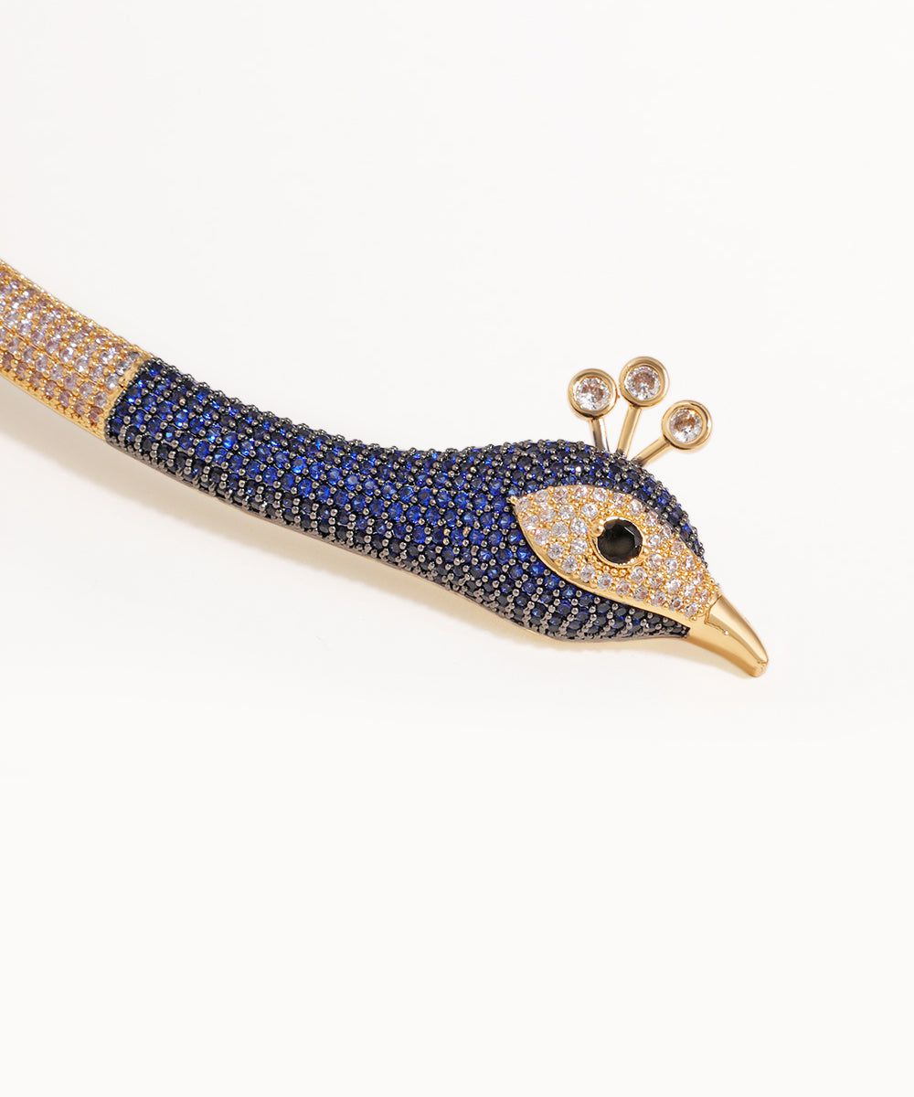 Decorative peacock feather with blue and gold details on a white background