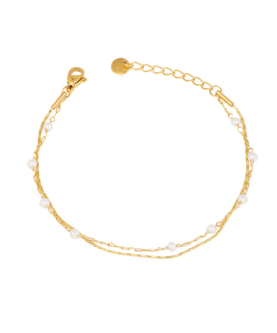 Gold-tone layered bracelet with delicate chains and interspersed faux pearls, lobster clasp.