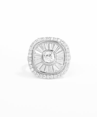 Silver brooch with central gemstone and surrounding diamonds on a white background