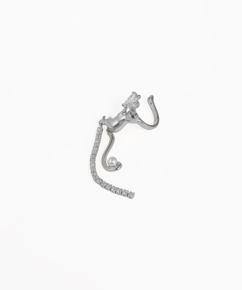 Silver earring with intricate design on a white background