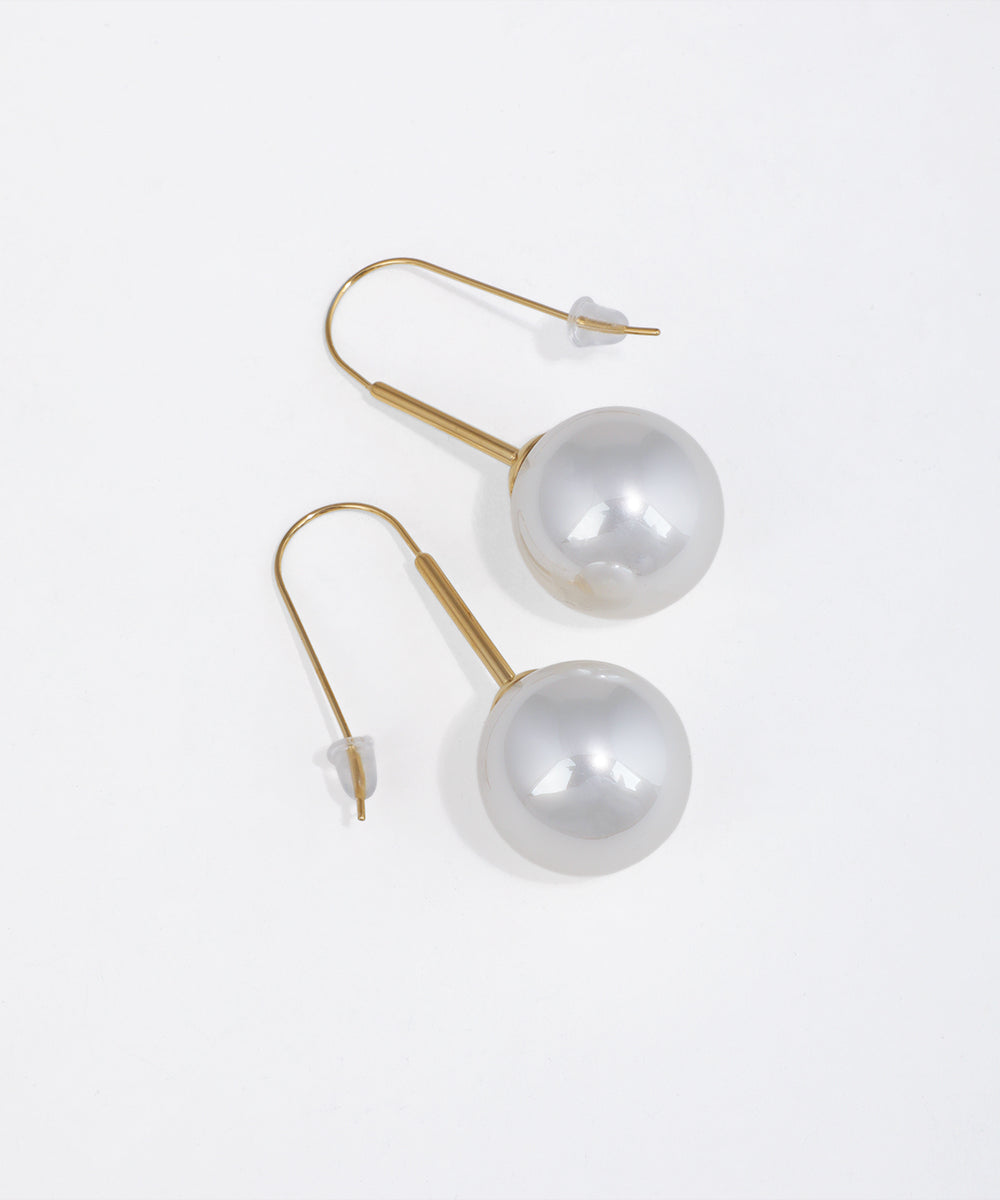 Gold-tone hook drop earrings with large, smooth faux pearl spheres