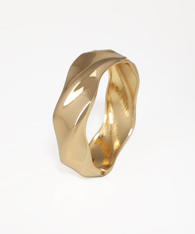 Gold ring with a twisted design on a white background