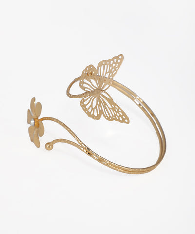 Gold-tone arm cuff with a large filigree butterfly and a small flower with a faux pearl center.