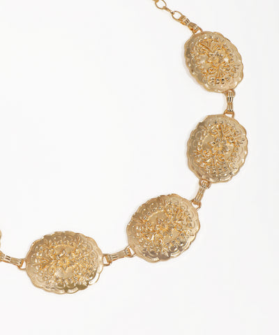 Gold necklace with intricate circular designs on a white background