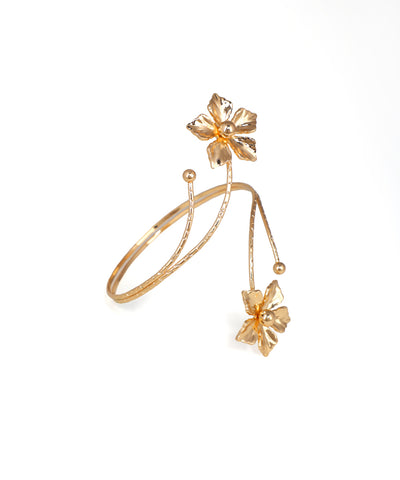 Gold bracelet with floral designs on a white background