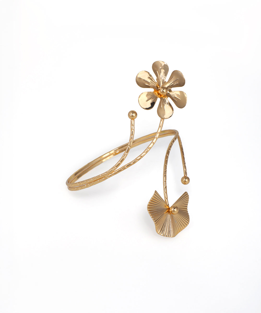 Gold bracelet with floral designs on a white background