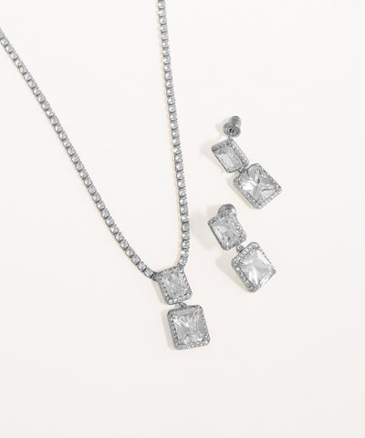 Silver necklace and earrings set on a white background