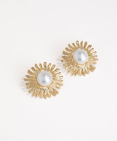 Gold earrings with pearl centers on a white background