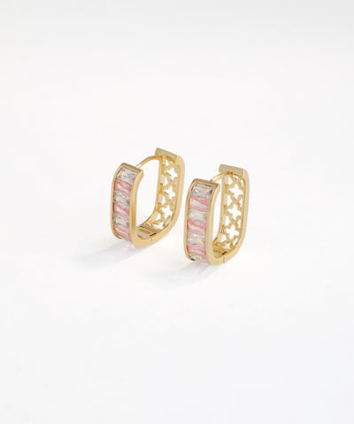 Gold hoop earrings with pink gemstones on a white background