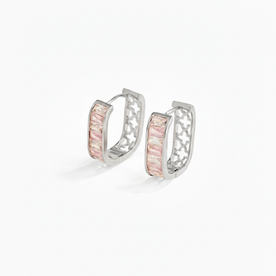 Pair of silver hoop earrings with pink gemstones on a white background