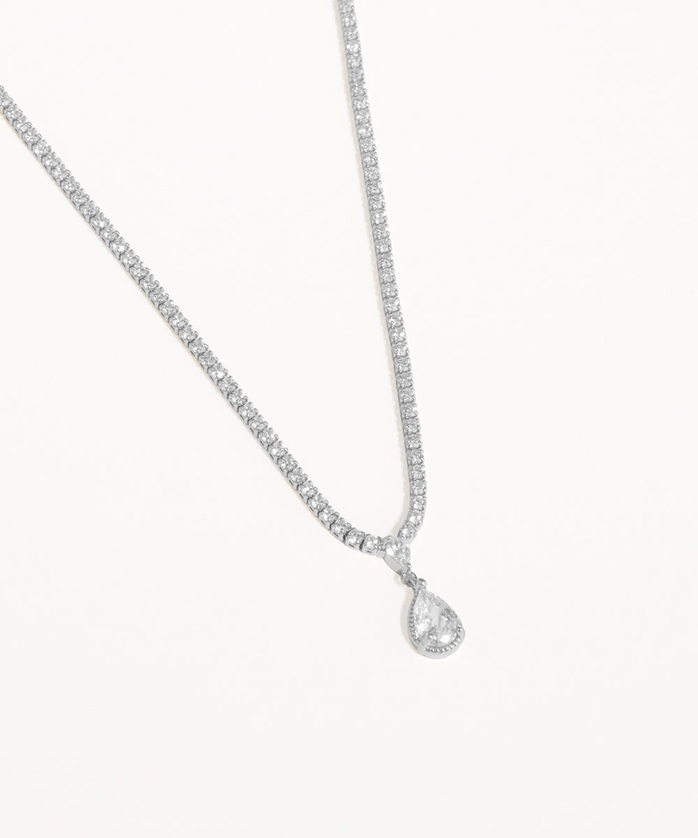 Silver necklace with a teardrop-shaped pendant on a white background