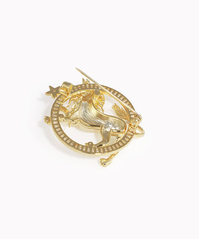 Gold brooch with a design on a white background