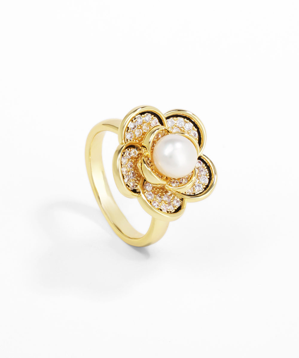 Gold ring with a pearl and small diamonds on a white background