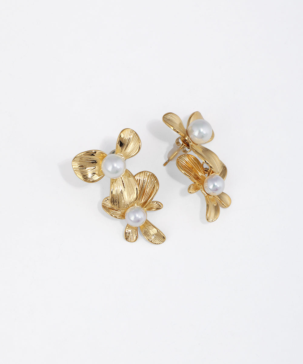 Gold-tone floral drop earrings with textured petals and faux pearls