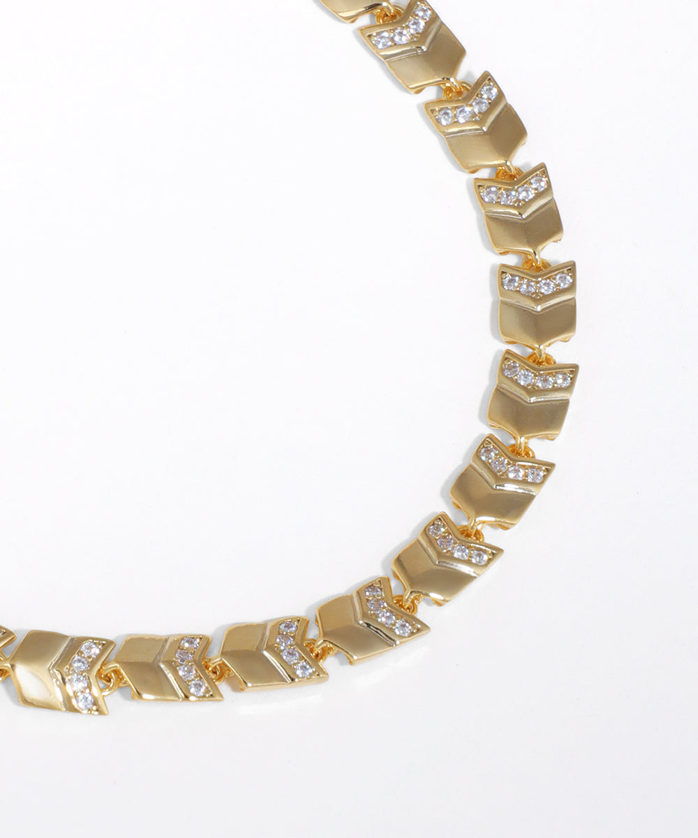 Gold bracelet with diamond accents on a white background