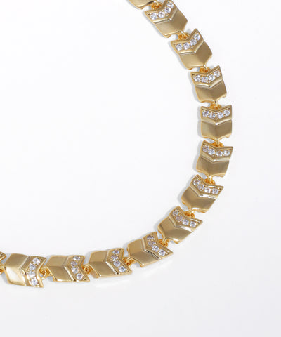 Gold bracelet with diamond accents on a white background