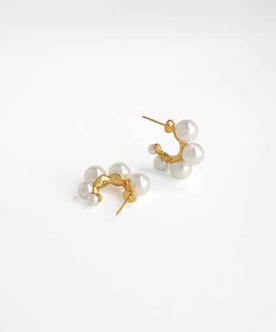 Pair of pearl earrings with gold posts on a white background