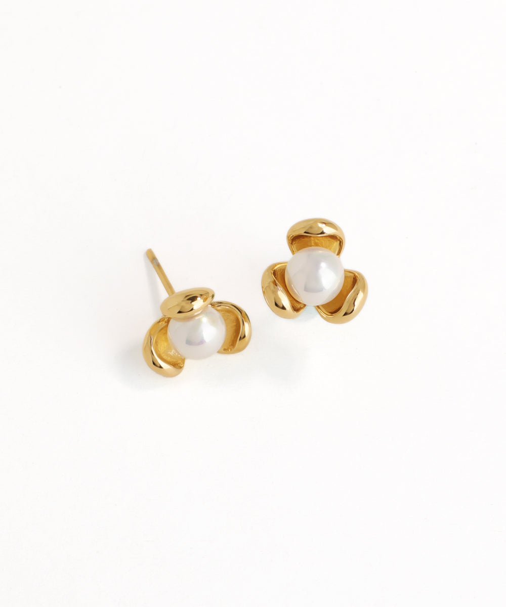 Gold earrings with pearl-like centers on a white background