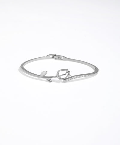Silver bracelet with heart charm on a white background