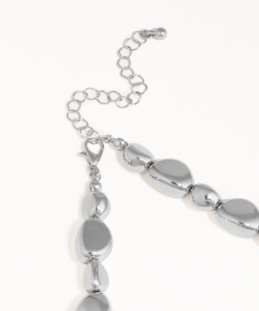 Silver bracelet with oval beads on a white background