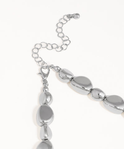 Silver bracelet with oval beads on a white background