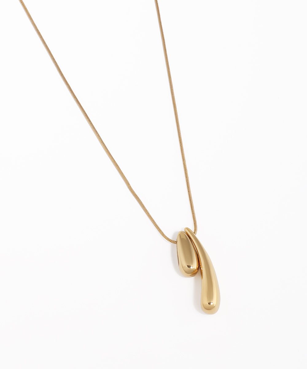 Gold necklace with a unique pendant on a white background