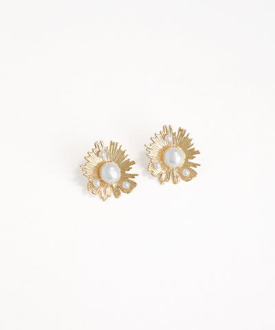 Gold earrings with pearl-like centers on a white background