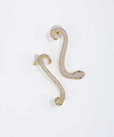 Gold-tone ear crawler earrings in a snake design, paved with clear CZ stones and green stone eyes.
