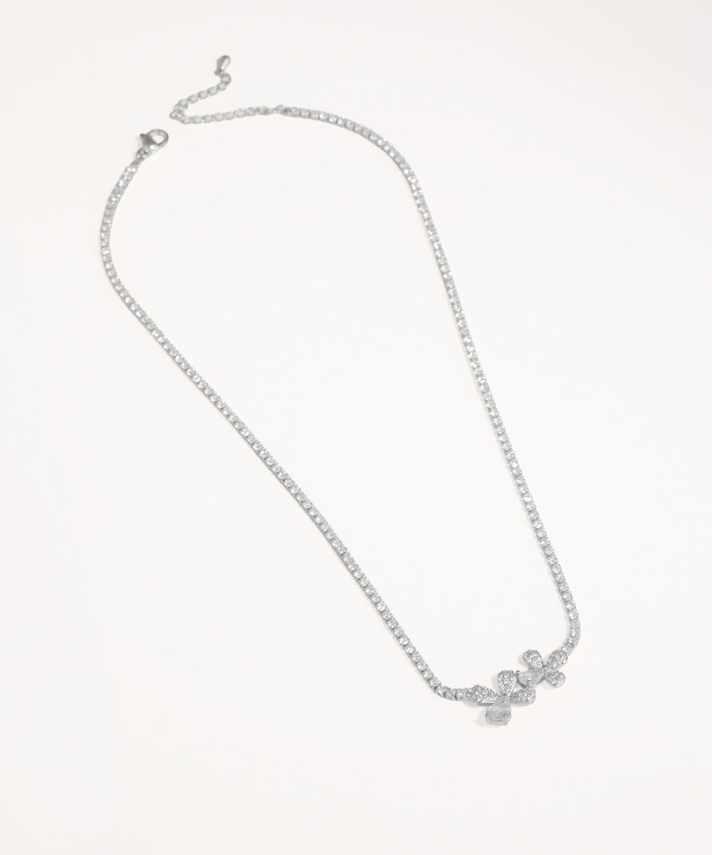 Silver necklace with a delicate pendant on a light gray background
