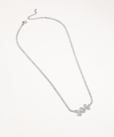 Silver necklace with a delicate pendant on a light gray background