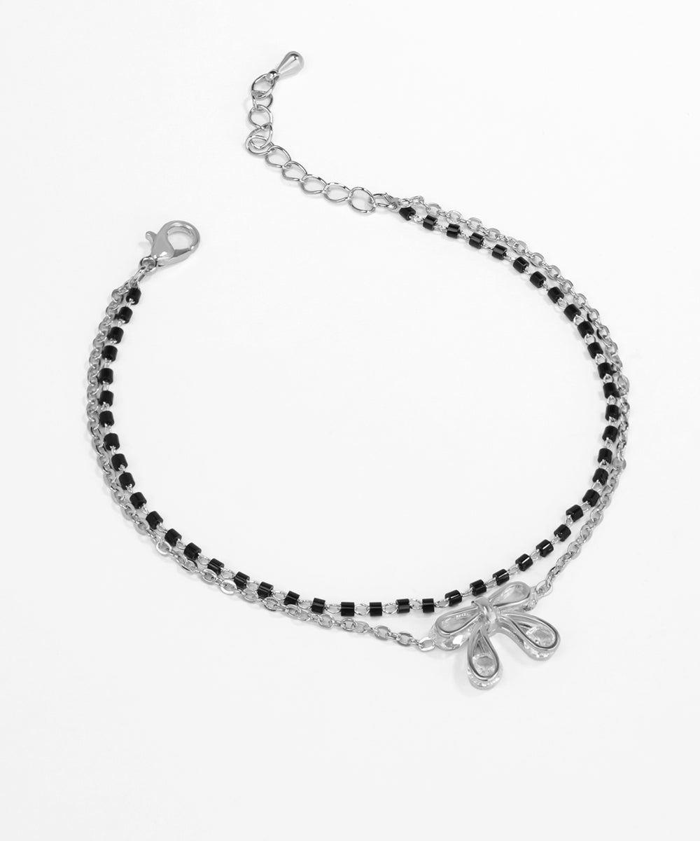 Silver bracelet with black beads on a white background