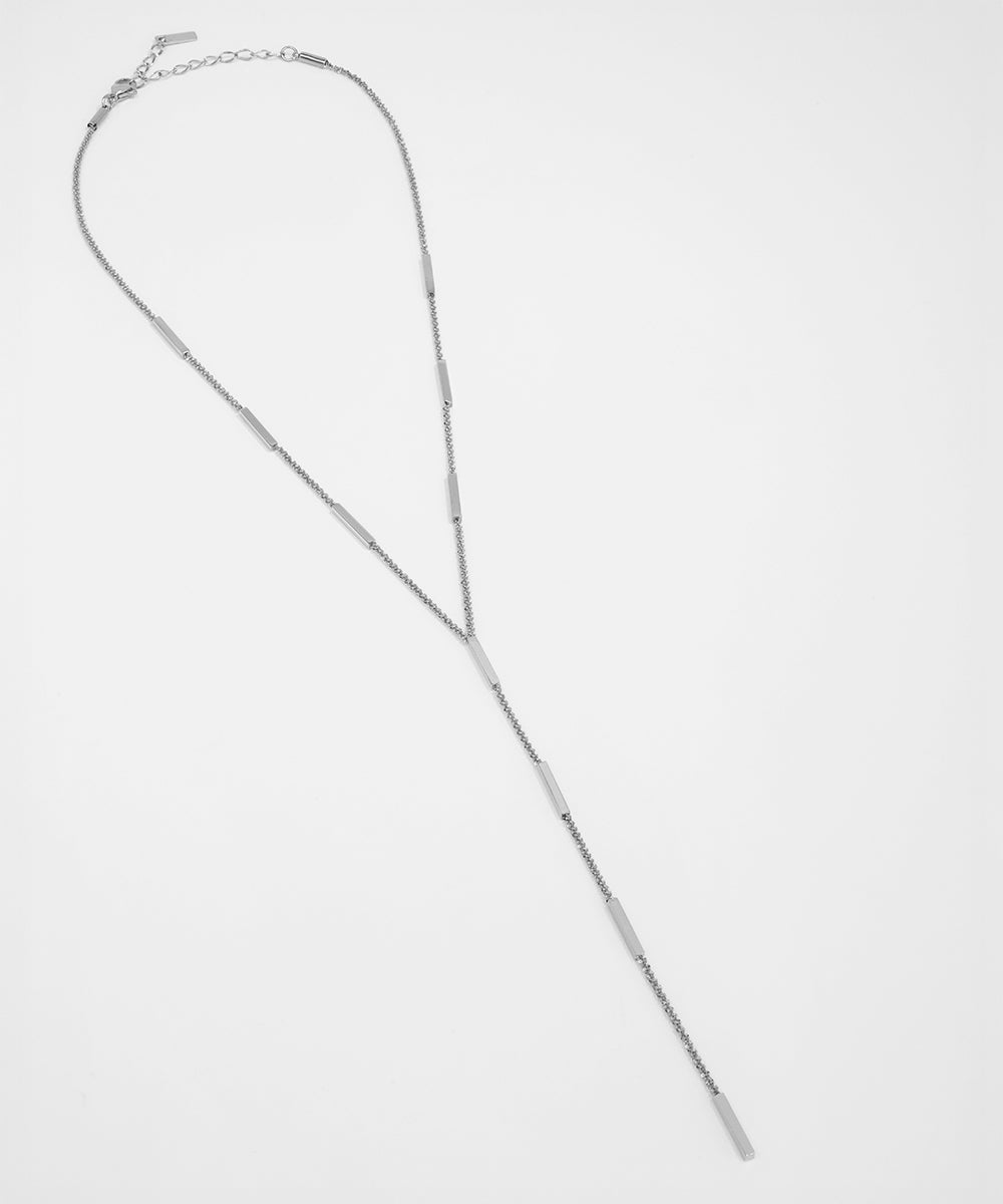 Silver necklace on a light gray background