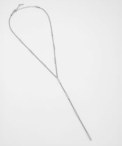 Silver necklace on a light gray background