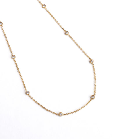 Gold necklace with small diamonds on a white background