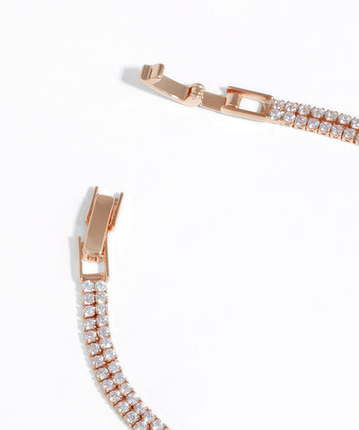 Rose gold bracelet with diamond accents on a white background