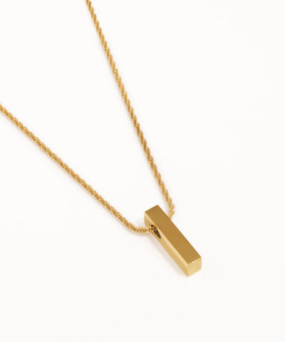 Gold necklace with a rectangular pendant on a white background