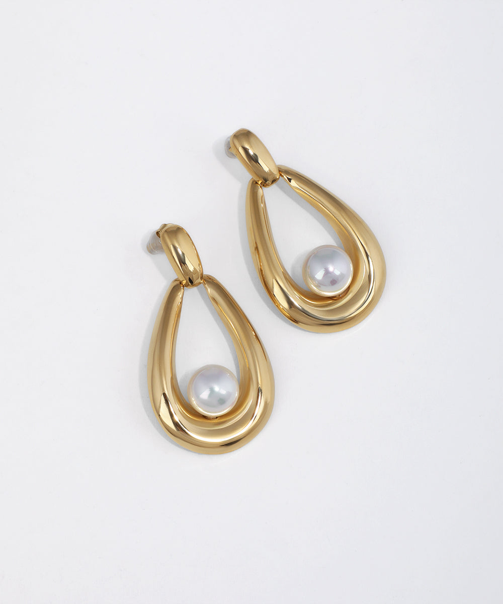 Gold-tone drop earrings with a smooth teardrop frame and a white faux pearl inside.