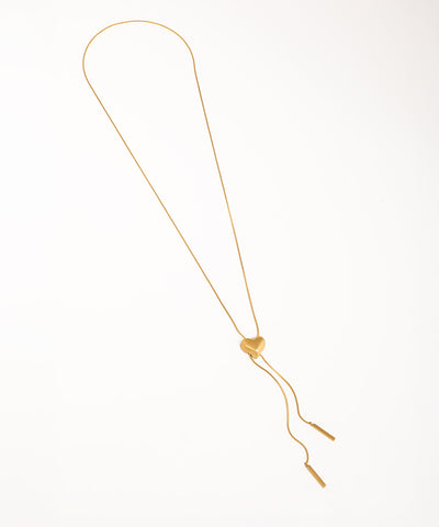 Gold-tone lariat necklace with a matte heart slider and bar tassels on a smooth chain