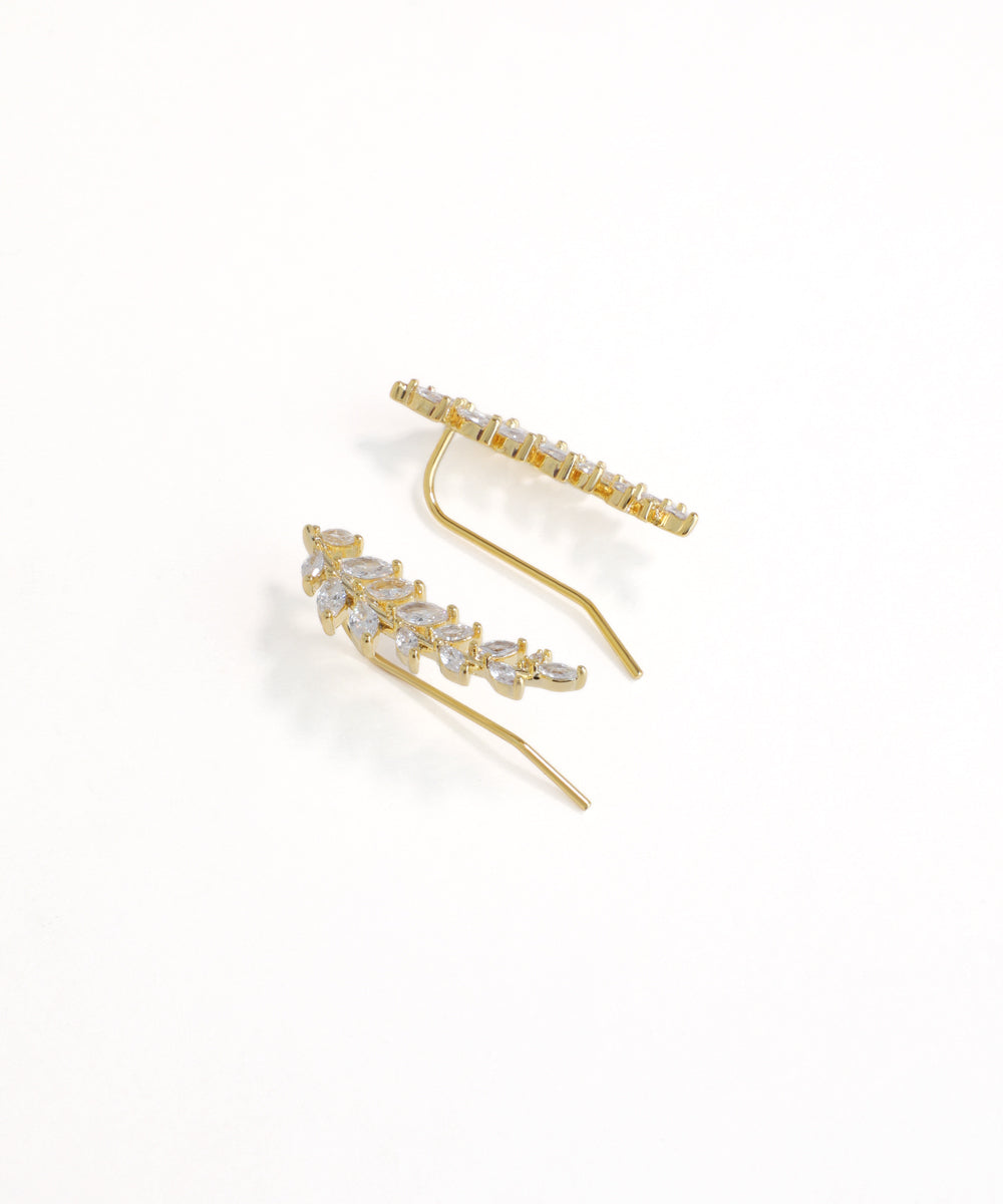 Gold earrings with clear gemstones on a white background