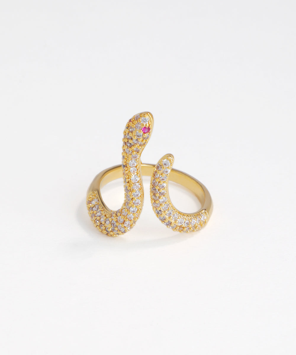 Gold snake-shaped ring with gemstones on a white background