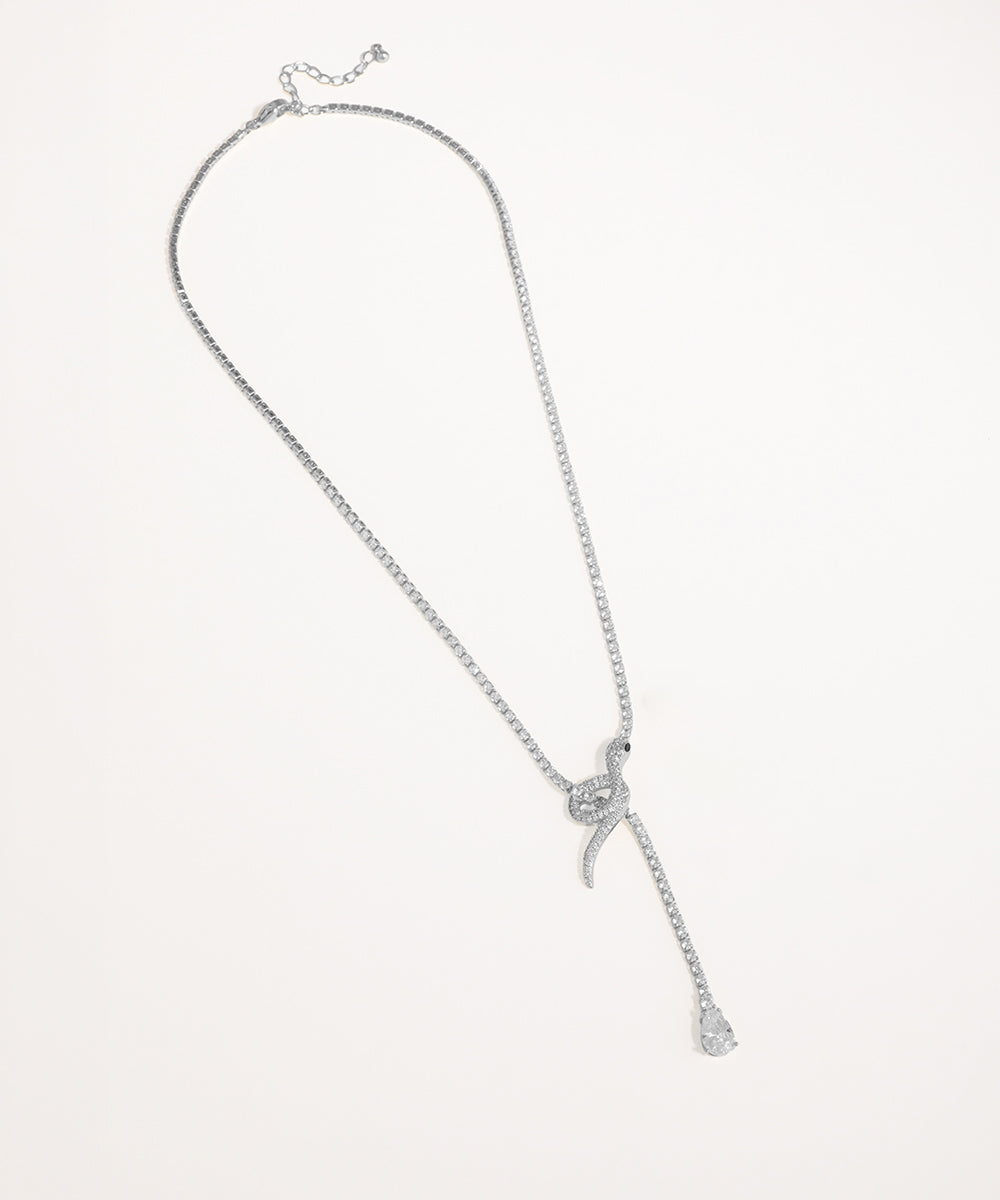 Silver necklace with a bow pendant on a light gray background