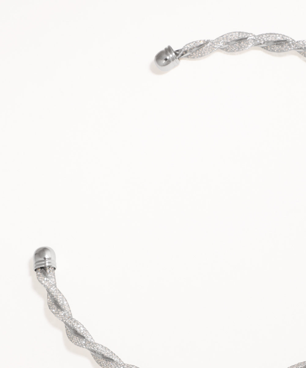 Silver bracelet with a braided design on a white background
