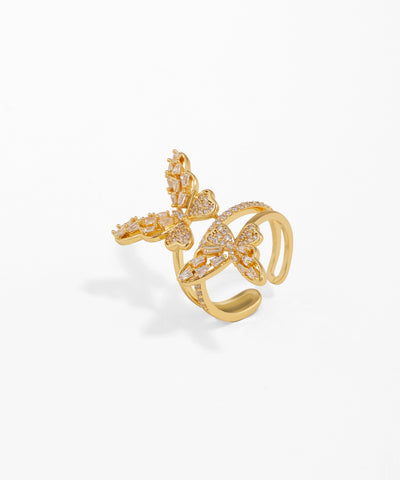 Gold-tone ring with two sparkling CZ-studded butterfly motifs, adjustable open band.