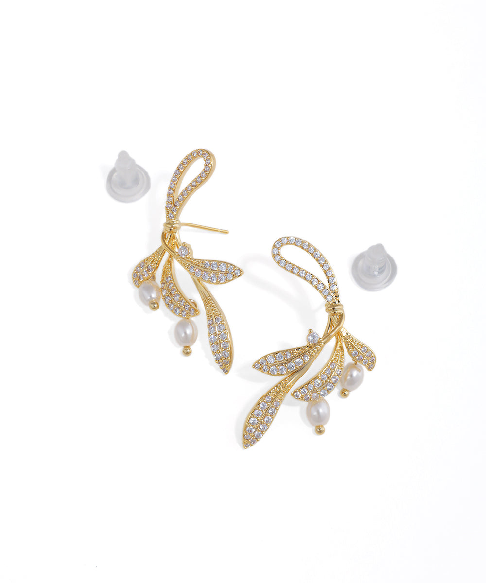 Gold-tone drop earrings with sparkling leaf motifs and faux pearl accents, featuring a natural vine design.