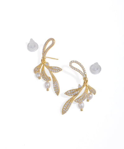 Gold-tone drop earrings with sparkling leaf motifs and faux pearl accents, featuring a natural vine design.