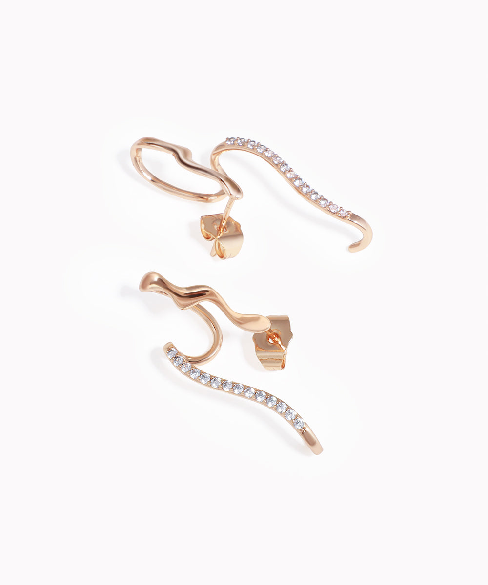 Rose-gold-tone ear climber earrings with a wavy design and clear CZ stones along one edge.