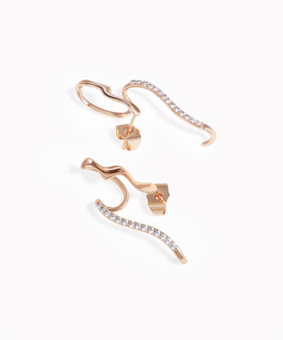 Rose-gold-tone ear climber earrings with a wavy design and clear CZ stones along one edge.